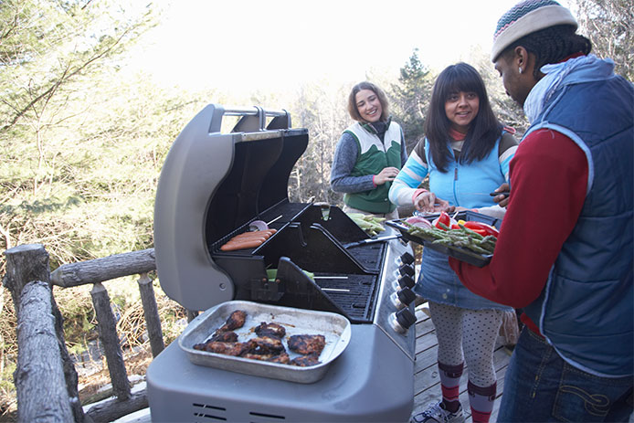 Young people grilling food on porch