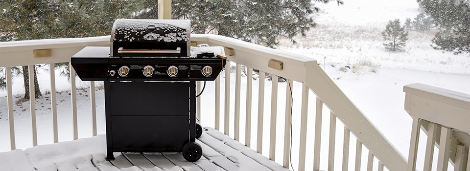 A grill on a porch in the winter