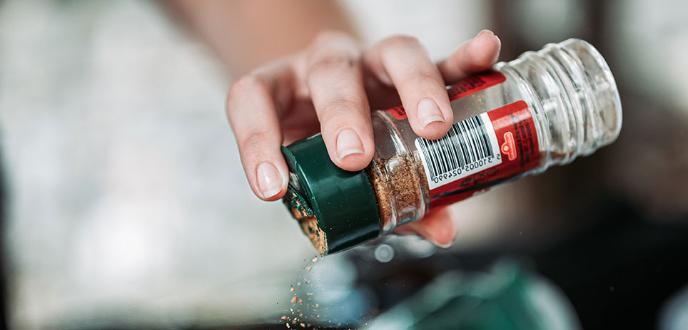 Shaking seasoning on to a steak