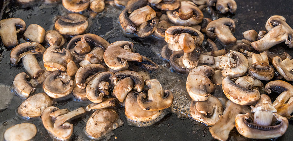 Mushrooms simmering on griddle top